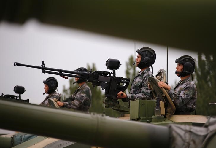 © Reuters. Soldiers of People's Liberation Army (PLA) stand inside tanks at a drill during an organised media tour at a PLA engineering academy in Beijing