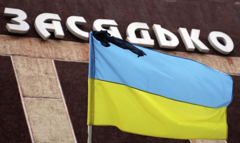 © Reuters. Флаг Украины с черной лентой у шахты имени Засядько 