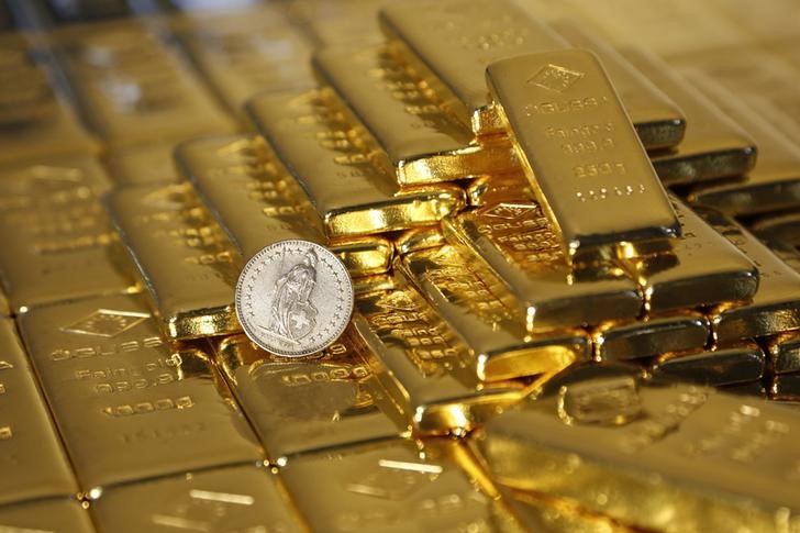 © Reuters. Слитки золота и монета в 1 швейцарский франк на заводе в Вене