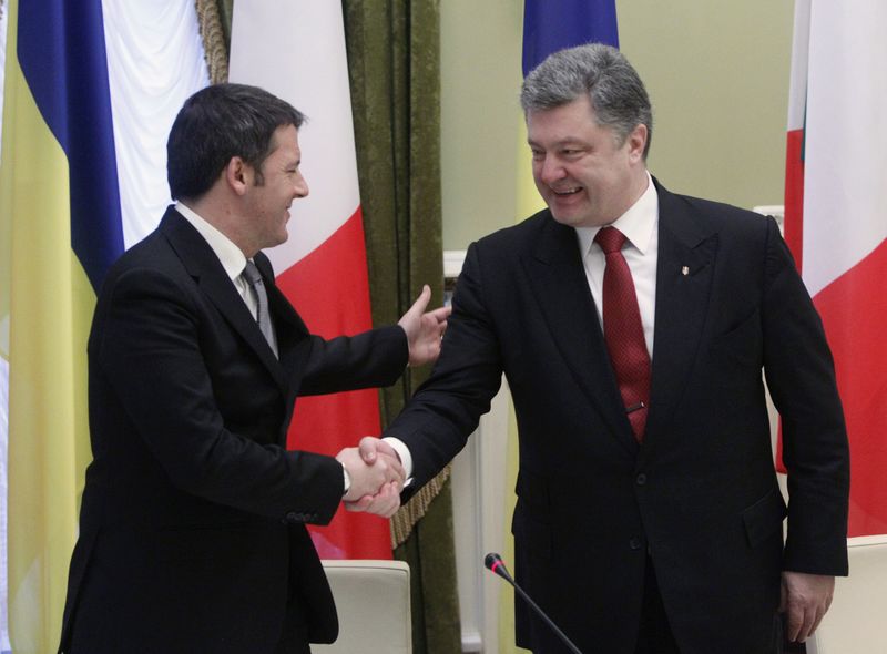 © Reuters. Ukrainian President Poroshenko shakes hands with Italian Prime Minister Renzi during a meeting with the media in Kiev