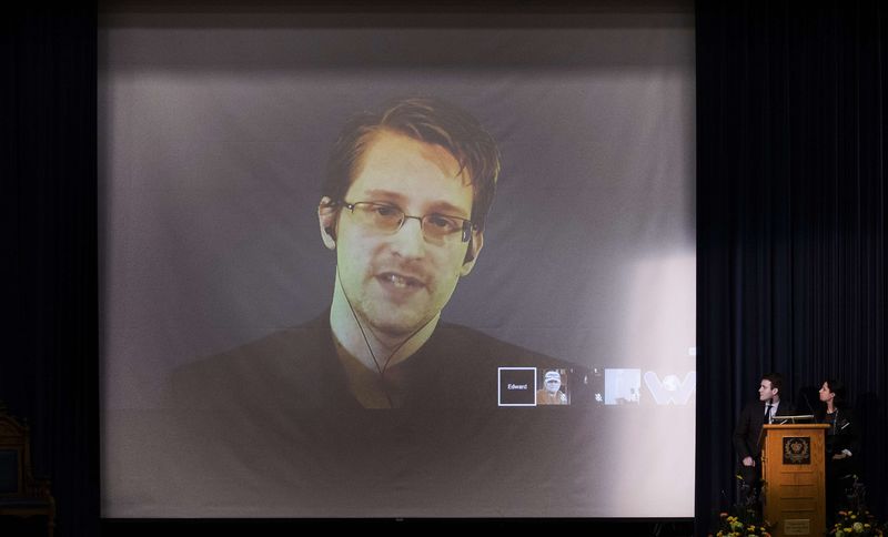 © Reuters. Former U.S. National Security Agency contractor Edward Snowden appears live via video with journalist Glenn Greenwald during a student organized world affairs conference at the Upper Canada College private high school in Toronto