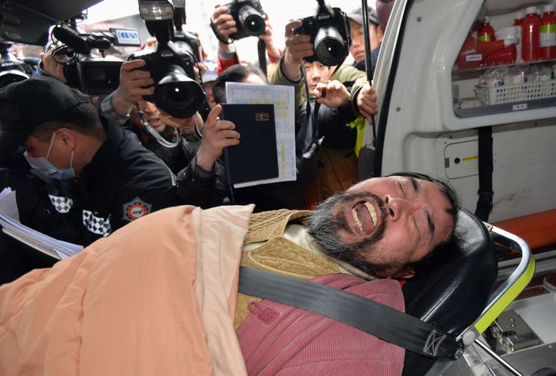 © Reuters. Kim Ki-jong who attacked the U.S. ambassador to South Korea Mark Lippert at a public forum, is carried on a stretcher off an ambulance as he arrives at a hospital in Seoul