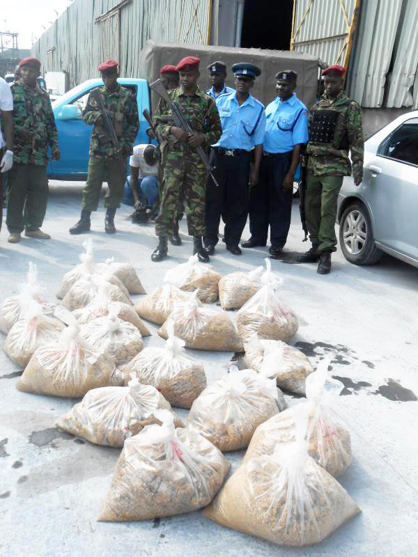 © Reuters. Kenyan policemen in Mombasa, guard bags of heroin discovered hidden in Mv Bushehr which had been seized by the Kenya Navy in the Indian Ocean