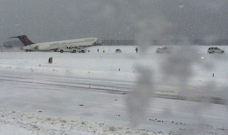 © Reuters. A Delta jet which skidded off the runway at Laguardia airport is attended by emergency personnel in New York City