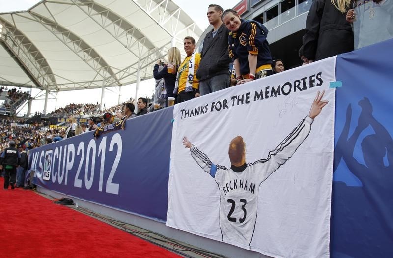 © Reuters. Fans thank Los Angeles Galaxy's David Beckham with a sign before the MLS Cup championship soccer game against the Houston Dynamo in Carson, California