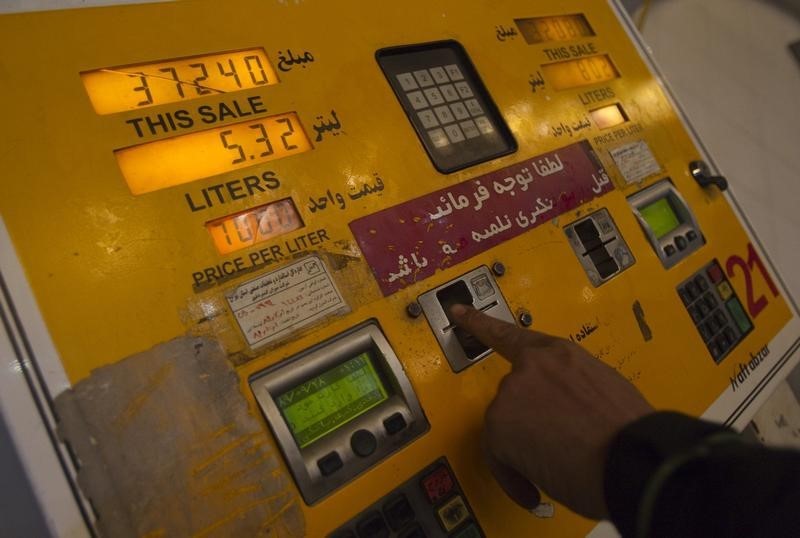 © Reuters. A man inserts a fuel smart card to start a pump at a petrol station in northwestern Tehran