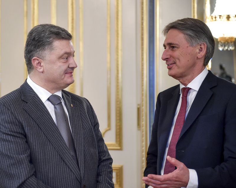 © Reuters. Handout photo of British Foreign Secretary Hammond talking to Ukrainian President Poroshenko prior to their meeting in Kiev