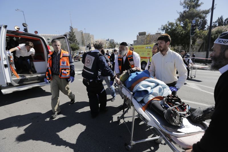 © Reuters. An Israeli policeman and medics evacuate an injured person at the scene of an attack in Jerusalem