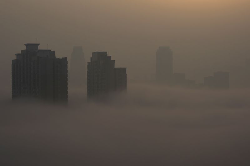 © Reuters. Prédios residenciais em meio a poluição em Wuhan, na província de Hubei