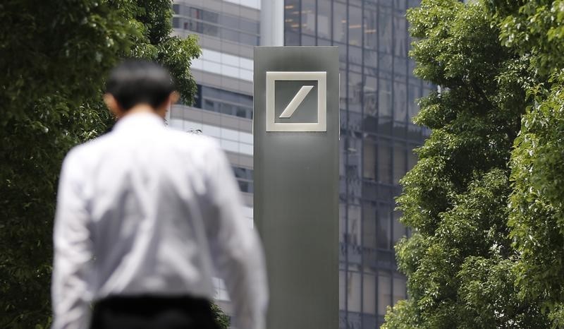© Reuters. Man walks near a logo of Deutsche Bank AG in Tokyo