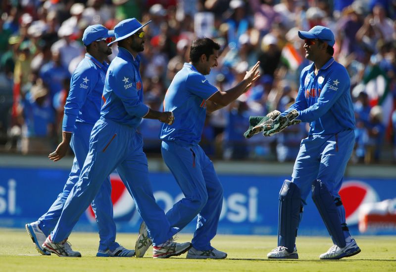 © Reuters. India's Mohit Sharma celebrates with team mates including wicketkeeper, captain MS Dhoni after Sharma caught out West Indies batsman Chris Gayle for 21 runs during their Cricket World Cup match in Perth