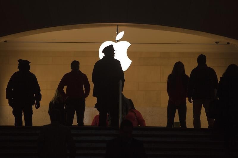 © Reuters. A police officer is silhouetted against the Apple logo in Grand Central Terminal in New York
