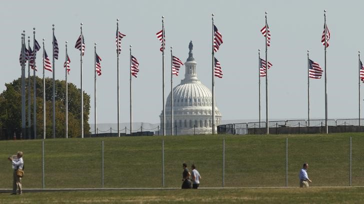© Reuters. The U.S. Capitol seen through flags on the first day of the government shutdown in Washington
