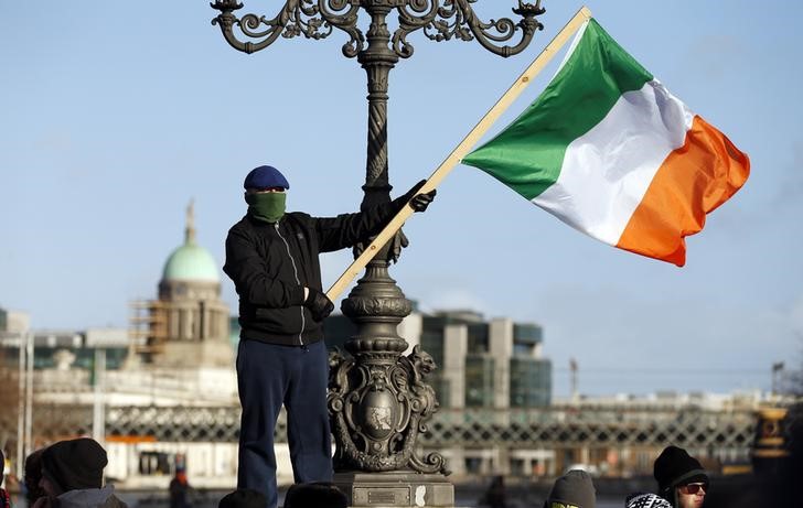 © Reuters. A demonstrator waves the national flag as people gather to protest against austerity policies and increases in water bills, according to local media, in central Dublin