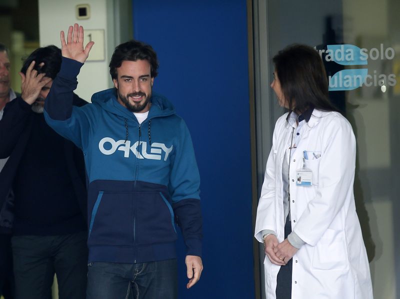 © Reuters. McLaren's Formula One driver Fernando Alonso of Spain waves to the media as he leaves the hospital where he was hospitalized since Sunday in Sant Cugat