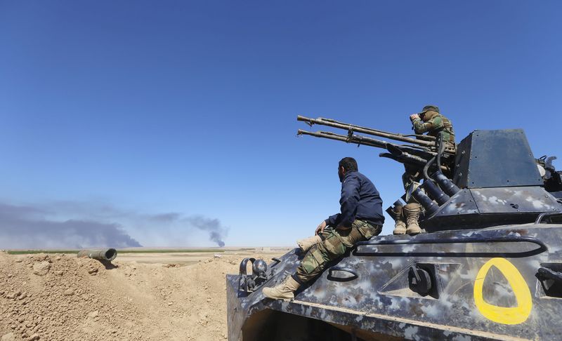 © Reuters. Combatentes xiitas em veículo militar em Al Hadidiya, Iraque
