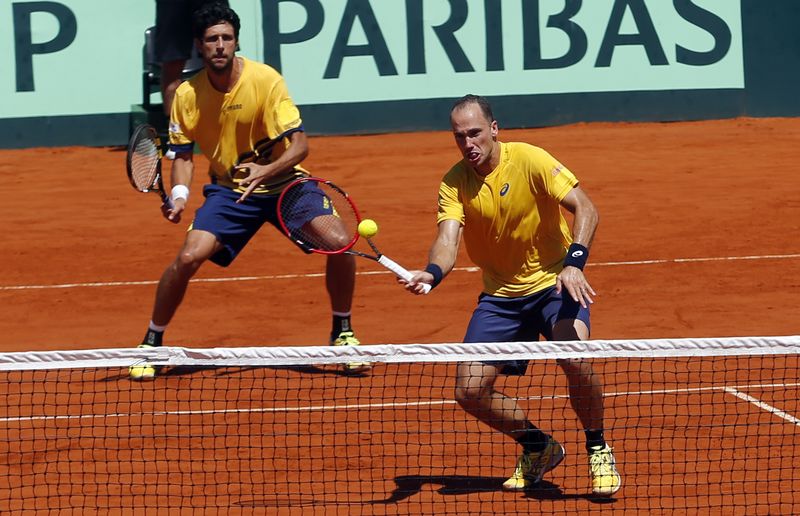 © Reuters. Melo and Soares of Brazil play a return shot to Argentines Berlocq and Schwartzman during their Davis Cup men's doubles tennis match in Buenos Aires