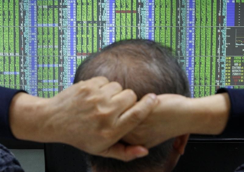 © Reuters. A man monitors stock market prices inside a brokerage in Taipei