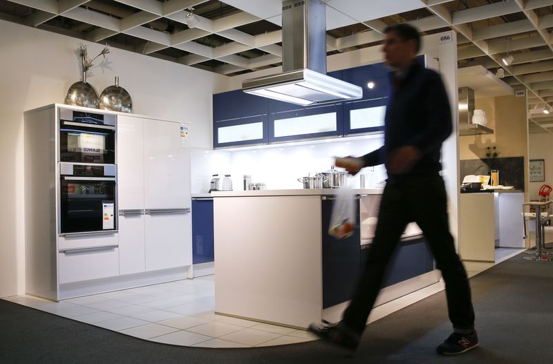 © Reuters. A man walks past at a kitchen by German kitchen maker Haecker inside a furniture shop in Berlin