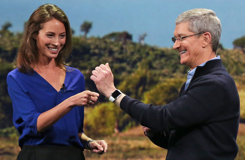 © Reuters. Model Christy Turlington Burns speaks to Apple CEO Tim Cook about the Apple Watch during an Apple event in San Francisco