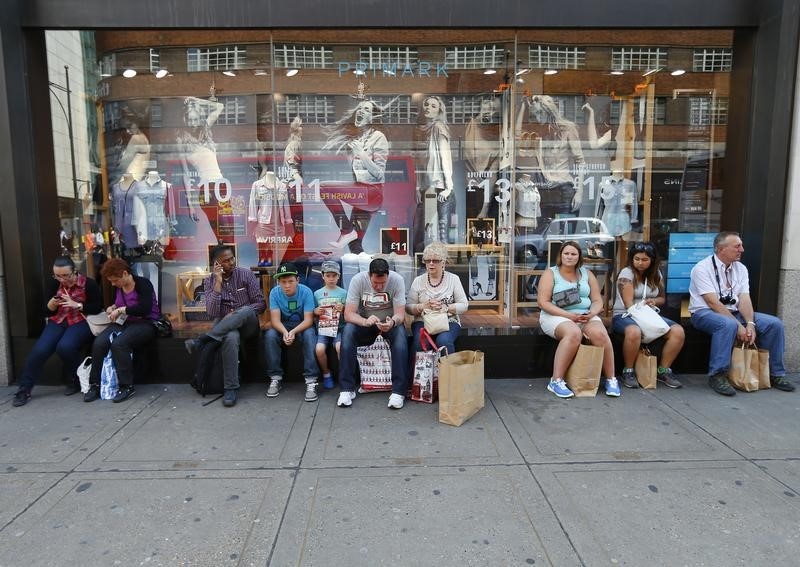 © Reuters. Shoppers sit with their bags on the window ledge of Primark on Oxford Street in London