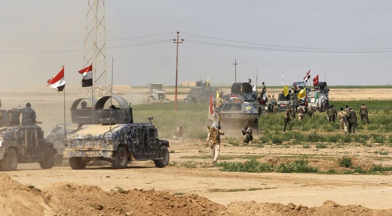 © Reuters. Shi'ite fighters and Iraqi security forces gather in the town of al-Alam