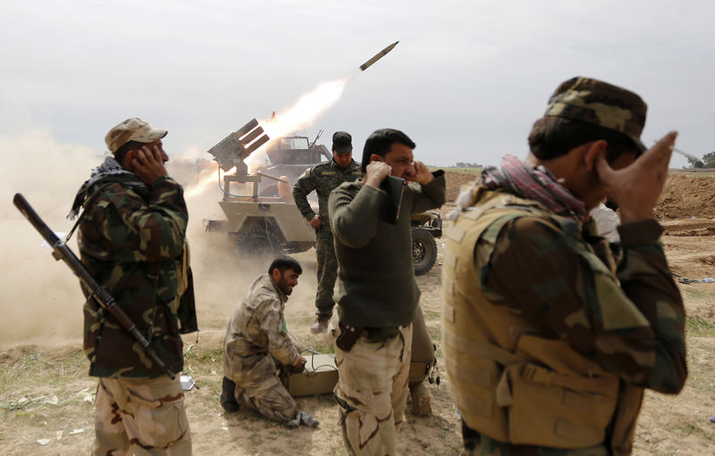 © Reuters. Combatentes xiitas lançando foguete durante confronto com militantes do Estado Islâmico na cidade de al-Alam
