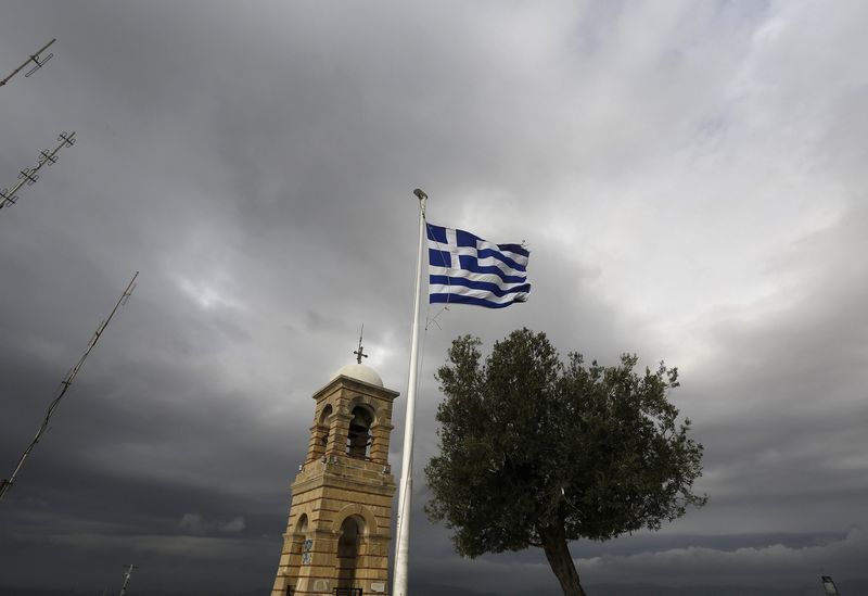 © Reuters. Greek flag flutters between Saint George's bell tower and an olive tree atop the Lycabettus hill