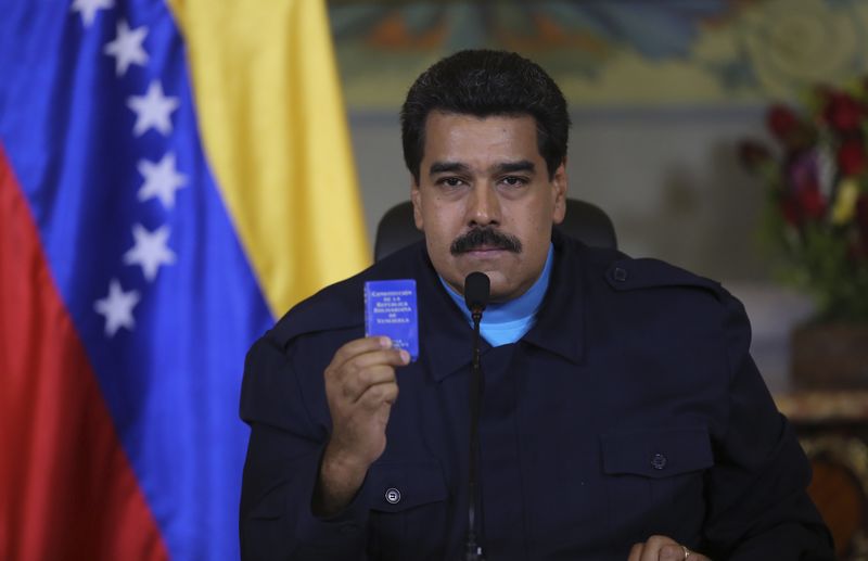 © Reuters. Venezuela's President Nicolas Maduro holds up a book of the country's constitution as he speaks during a national TV broadcast in Caracas