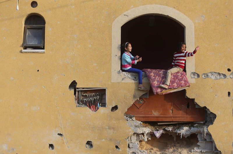 © Reuters. Palestinian girls play at their family's house, that witnesses said was damaged by Israeli shelling during a 50-day war last summer, in Khan Younis in the southern Gaza Strip