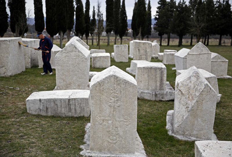 © Reuters. A worker cleans a tombstone at Radimlja necropolis near Stolac