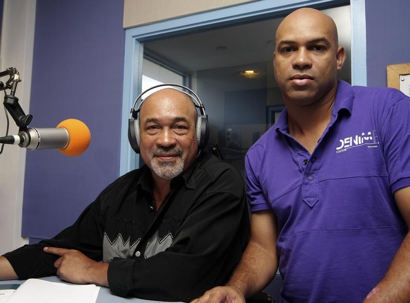 © Reuters. Former Surinamese dictator Desi Bouterse, head of the opposition National Democratic Party (NDP), pose with his son Dino during a live radio show in Paramaribo