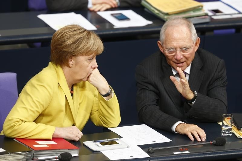 © Reuters. German Chancellor Merkel talks with Finance Minister Schaeuble prior to vote on the federal budget at Bundestag in Berlin