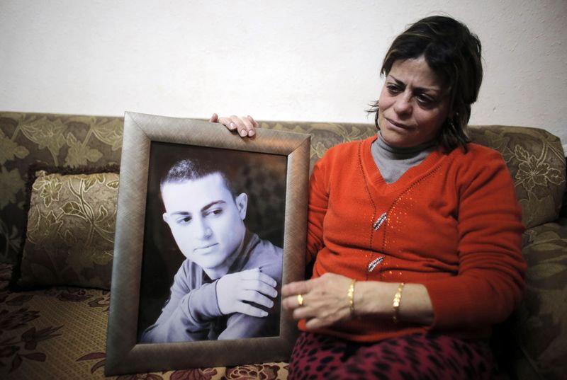 © Reuters. The mother of Muhammad Musallam, an Israeli Arab held by Islamic State in Syria as an alleged spy, weeps as she holds his photograph in her East Jerusalem home