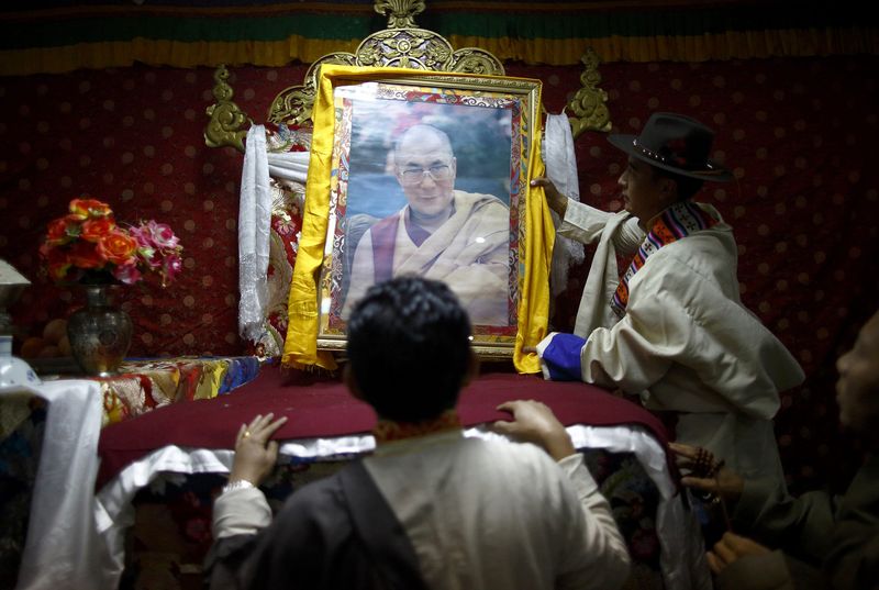 © Reuters. A Tibetan man carries a portrait of exiled Tibetan spiritual leader, the Dalai Lama, during the function organised to mark "Losar" or the Tibetan New Year at a Tibetan Refugee Camp in Lalitpur