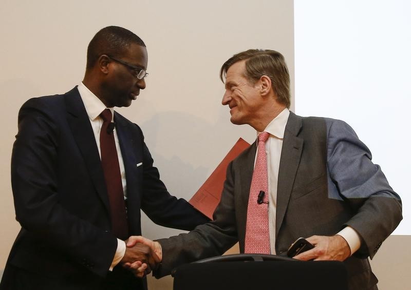 © Reuters. Credit Suisse outgoing Chief Executive Dougan and Thiam shake hands after a Credit Suisse news conference in Zurich