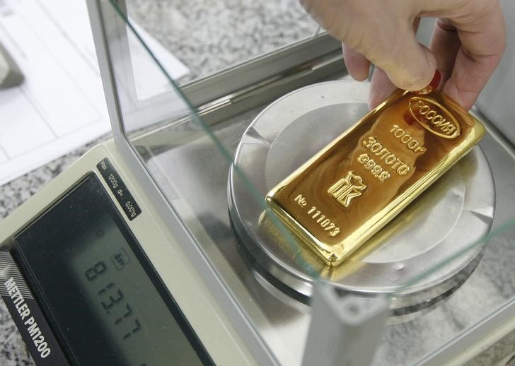 © Reuters. Рабочий завода Красцветмет взвешивает слиток золота 