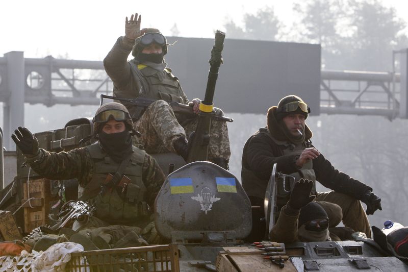 © Reuters. Ukrainian servicemen ride atop an armoured personnel carrier in Kiev