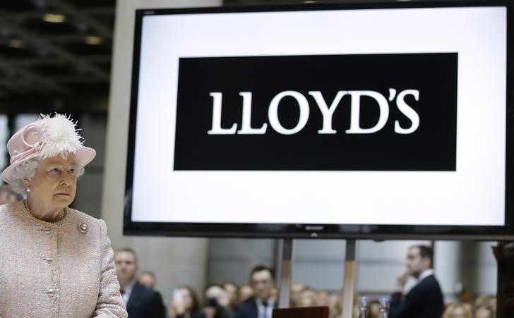 © Reuters. Britain's Queen Elizabeth II  stands next to a sign during a visit to Lloyd's of London