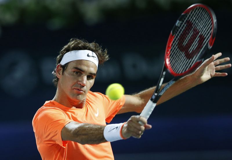 © Reuters. Roger Federer returns the ball to Novak Djokovic during their final match at the ATP Championships tennis tournament in Dubai