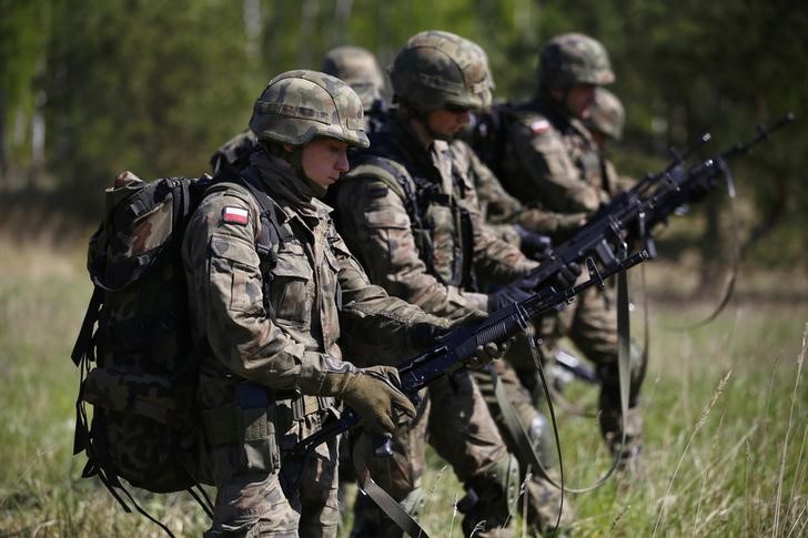 © Reuters. Polish 6 Airborne Brigade soldiers check their weapons as they participate in training exercises with paratroopers from the U.S. Army's 173rd Infantry Brigade Combat Team in Poland