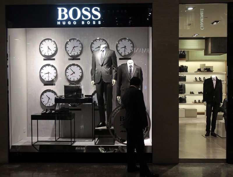 © Reuters. File photo of a man looking at a shop window outside the Hugo Boss showroom inside a shopping mall in Mumbai