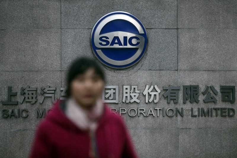 © Reuters. Woman walks past the gate of SAIC Motor Corporation Limited in Shanghai