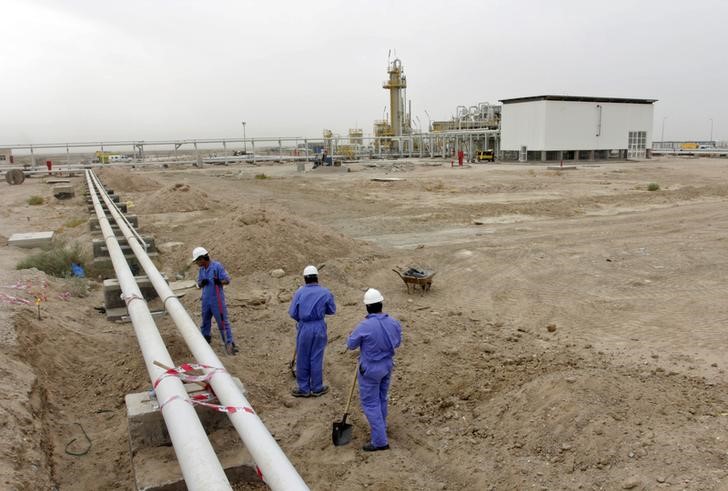 © Reuters. Рабочие на нефтяном месторождении Западная Курна в Басре 