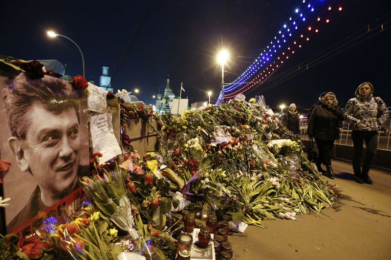 © Reuters. People walk past flowers at site where Russian politician Nemtsov was killed in central Moscow