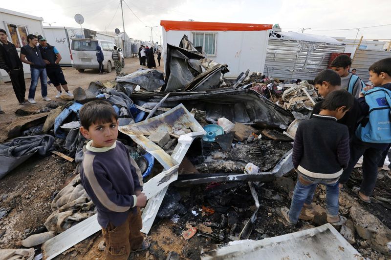© Reuters. Crianças refugiadas olhando destroços na Síria