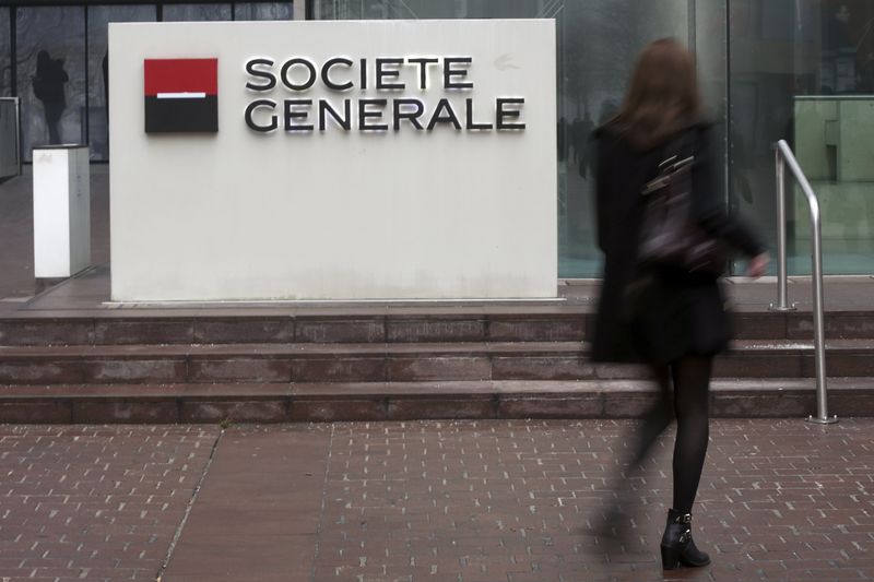 © Reuters. A woman walks past the logo of French bank Societe Generale as she enters the bank's headquarters in La Defense near Paris