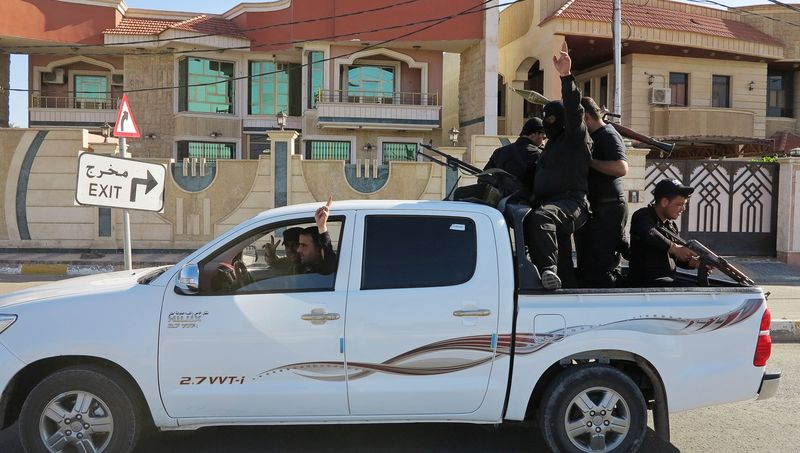 © Reuters. Sunni tribal fighters ride in a vehicle with their weapons as they guard against possible attacks from Islamic State militants, in Ramadi