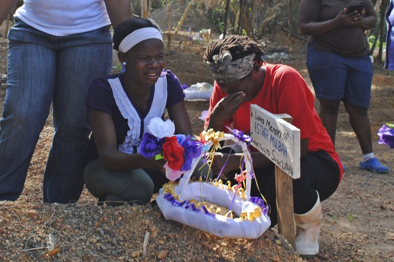 © Reuters. Mulheres choram morte de parente em cemitério para vítimas do Ebola na Libéria 