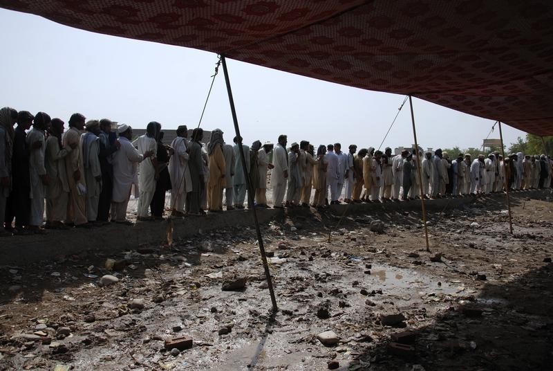 © Reuters. Men fleeing military offensive in North Waziristan queue to get relief handouts in Bannu
